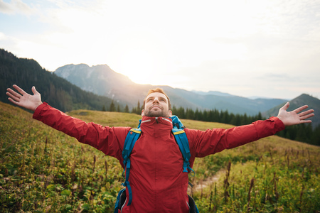 Hiker with arms raised embracing a new dayの写真素材
