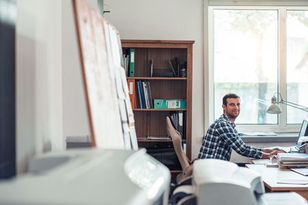 Smiling businessman working on a computer in an office