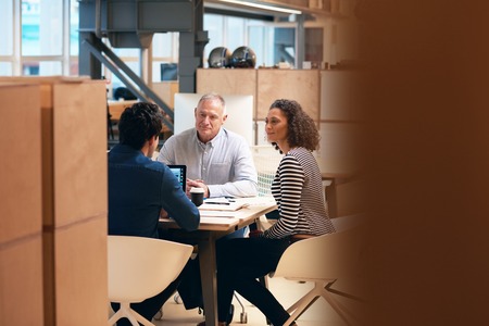 Coworkers talking business together in a modern officeの写真素材