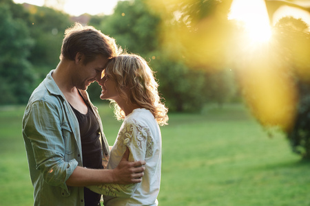 Young couple enjoying a romantic moment outside at sunsetの写真素材