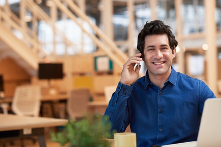 Positive young businessman hard at work in a modern office