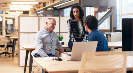 Office colleagues having a discussion together in an office