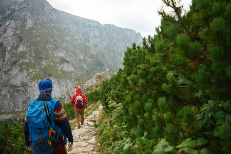 Two men hiking along a rocky trail in the mountainsの写真素材