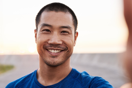 Athletic Asian man taking a selfie during a morning runの写真素材