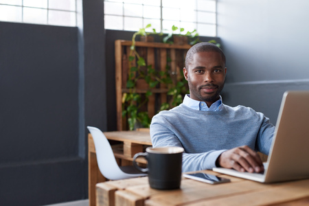 Young African businessman working on a laptop in an office