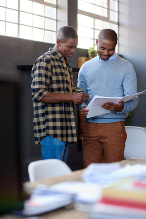 African business colleagues discussing paperwork together in an officeの写真素材