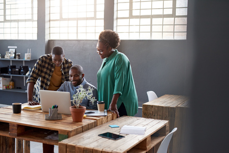 African businesspeople using a laptop together in a modern officeの写真素材