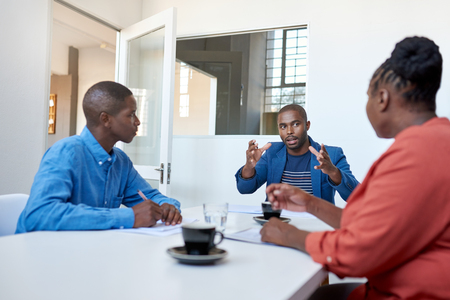 African businessman talking with colleagues in a modern officeの写真素材