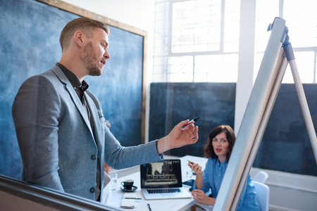 Young businessman giving colleagues a presentation in an office