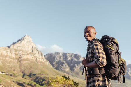 Smiling young African man enjoying the view while out hikingの写真素材