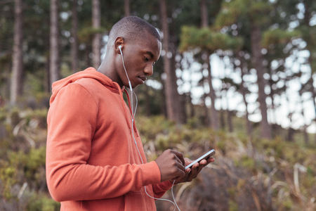 Fit young African man listening to music before a runの写真素材