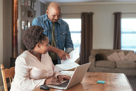 African couple doing online banking together at homeの写真素材