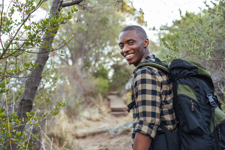 Smiling young African man hiking in the hillsの写真素材