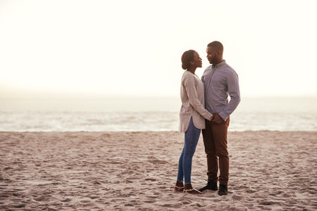 Content young African couple standing on a beach at duskの写真素材