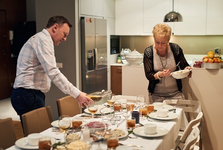 Family setting the dining table together for christmas dinnerの写真素材