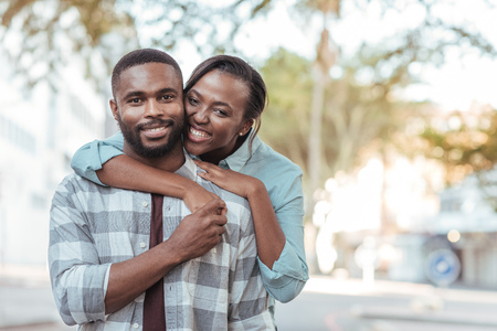 Content African couple standing together outside on a sunny dayの写真素材
