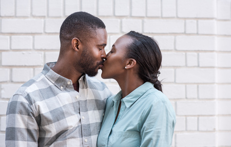 Romantic young African couple kissing each other in the cityの写真素材