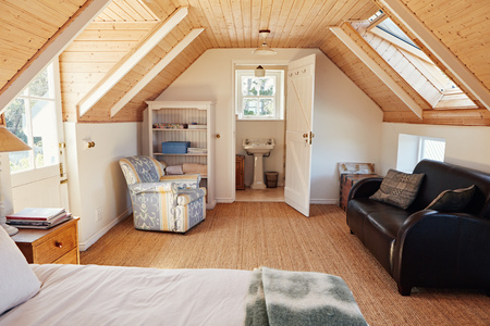 Interior of an attic bedroom with bathroom in a homeの写真素材