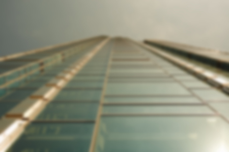 Blurred modern glass skyscraper against the sky in a city
