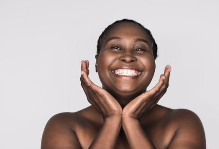Smiling African woman with perfect skin against a gray backgroundの写真素材