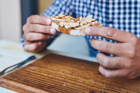 Man holding an open faced sandwich at a bistro tableの写真素材