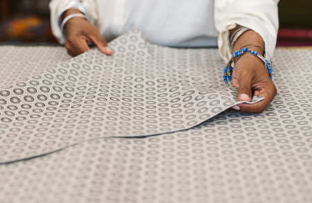 Closeup of a woman inspecting textiles in her fabric shopの写真素材