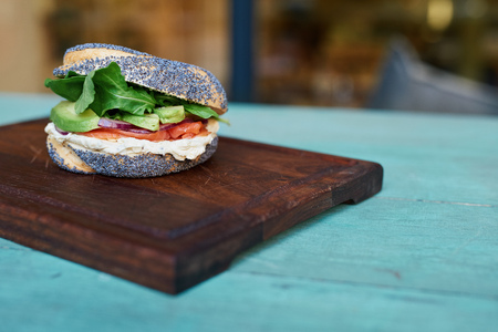 Salmon and cream cheese bagel on a rustic turquoise tableの写真素材