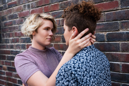 Affectionate young lesbian couple looking into each others eyes outsideの写真素材