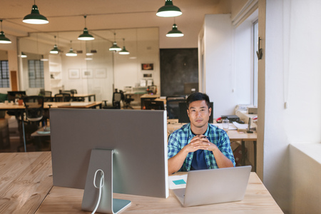 Focused young designer sitting at his workstation in an officeの写真素材