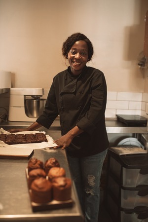 Smiling baker working at the counter of a commercial kitchenの写真素材