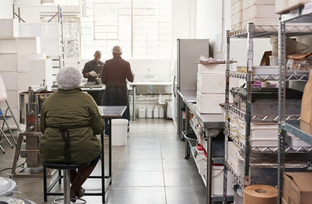 Small artisanal chocolate making factory with people workingの写真素材
