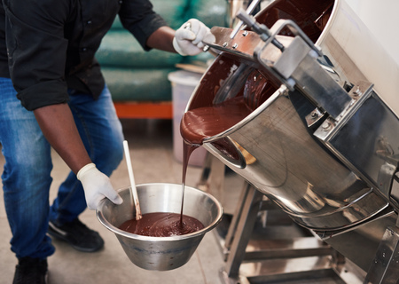 Worker melting chocolate while at work in a confectionary factoryの写真素材