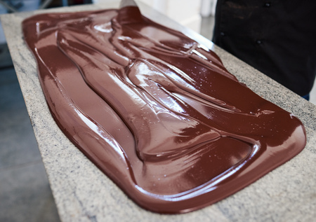 Worker mixing chocolate spread out on a factory tableの写真素材