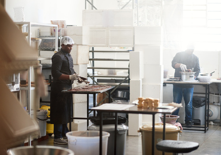 Worker cooling chocolate on a confectionary making factory tableの写真素材