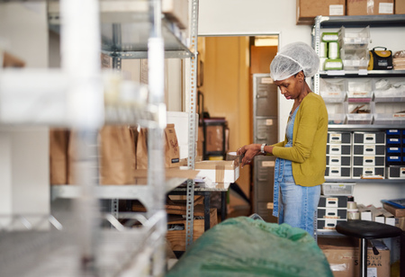 Confectionary making factory worker preparing boxes of chocolate for shipment