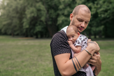 Loving young father cradling his adorable baby boy outsideの写真素材