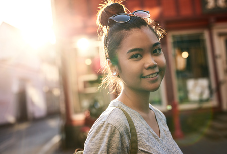 Smiling young Asian woman walking in the cityの写真素材