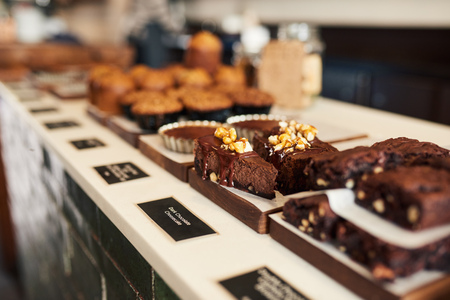 Assortment of delicious desserts in a bakerys glass display caseの写真素材