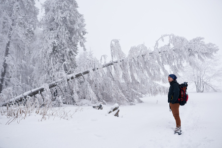 Young man appreciating a snow covered winter landscapeの写真素材