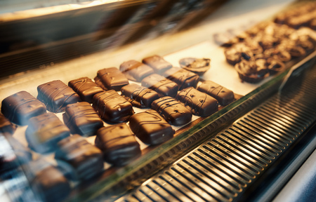 Delicious asortment of chocolate sitting in a shop display caseの写真素材