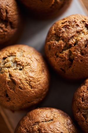 Freshly baked muffins cooling on a serving boardの写真素材