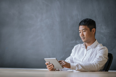 Asian businessman working on a tablet in an officeの写真素材