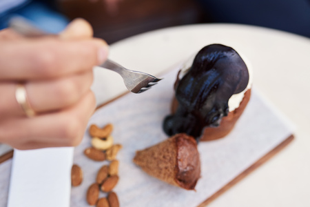 Woman eating a delicious dessert at a bistro tableの写真素材