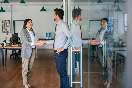 Businessman shaking hands with a new employee in an officeの写真素材