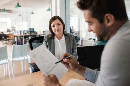 Smiling manager interviewing an applicant in his office