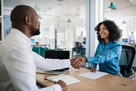 Smiling manager shaking hands with an applicant after an interviewの写真素材