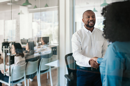 Smiling manager shaking hands with a new employee