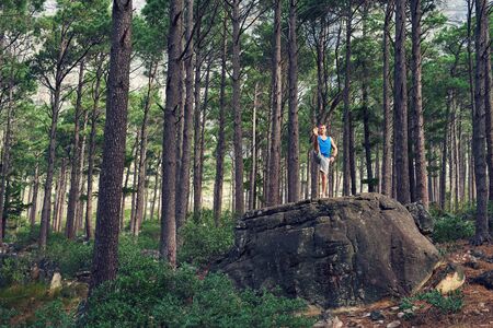 Man doing the extended hand to toe pose in a forestの写真素材