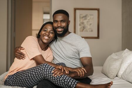 African American couple sitting on their bed in the morningの写真素材