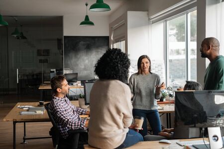Diverse designers discussing a project together in their officeの写真素材
